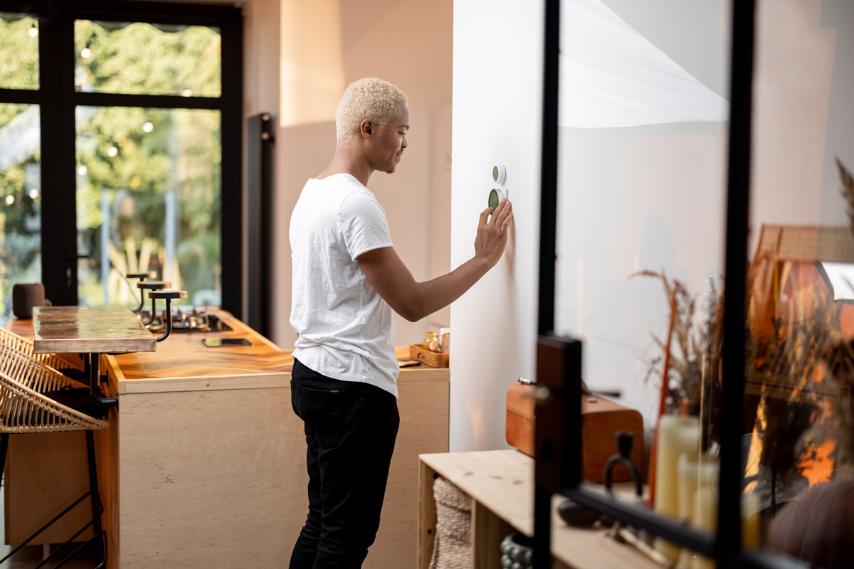 A man programming the Smart Thermostat on the wall